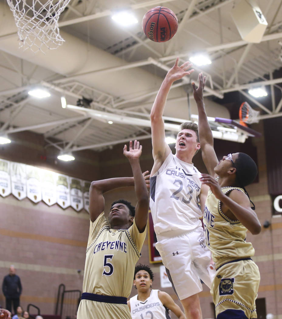 Faith Lutheran’s Brevin Walter (23) goes to the basket between Cheyenne’s Glenn ...