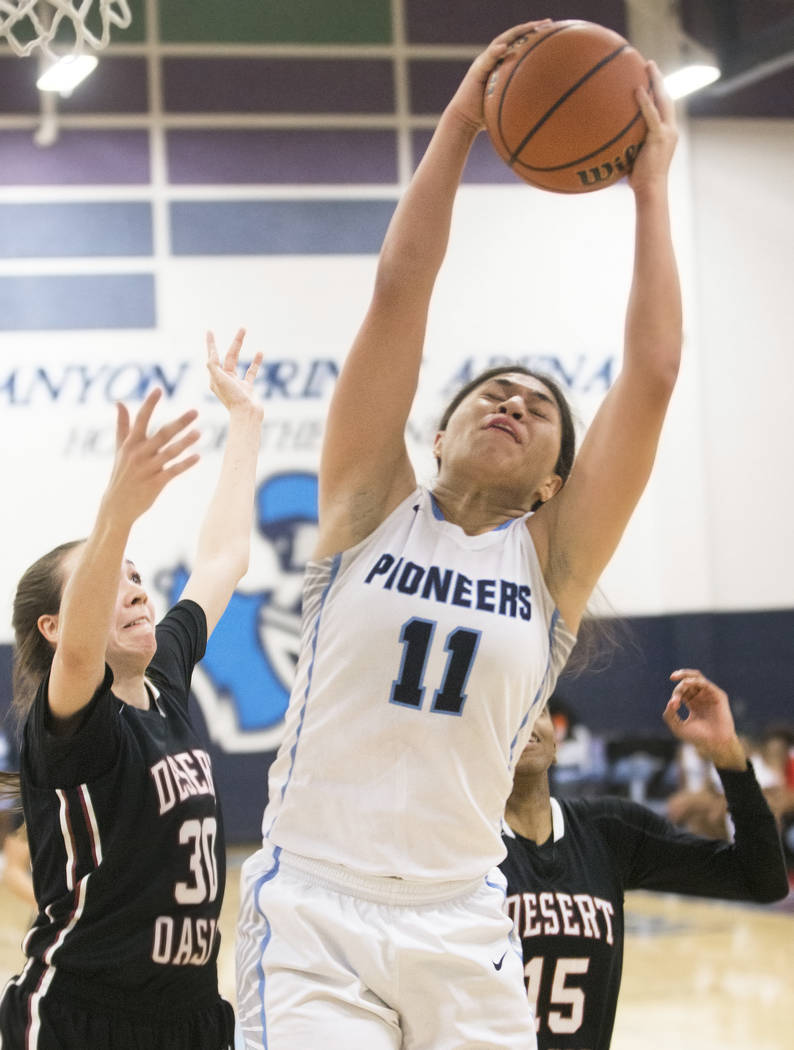 Canyon Springs junior forward Jeanette Fine (11) grabs a rebound over Desert Oasis senior fo ...