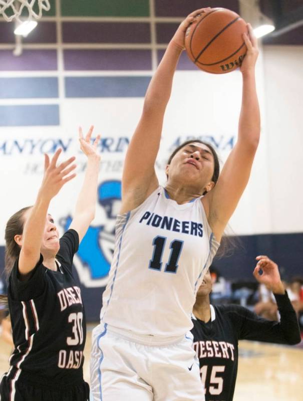 Canyon Springs junior forward Jeanette Fine (11) grabs a rebound over Desert Oasis senior fo ...