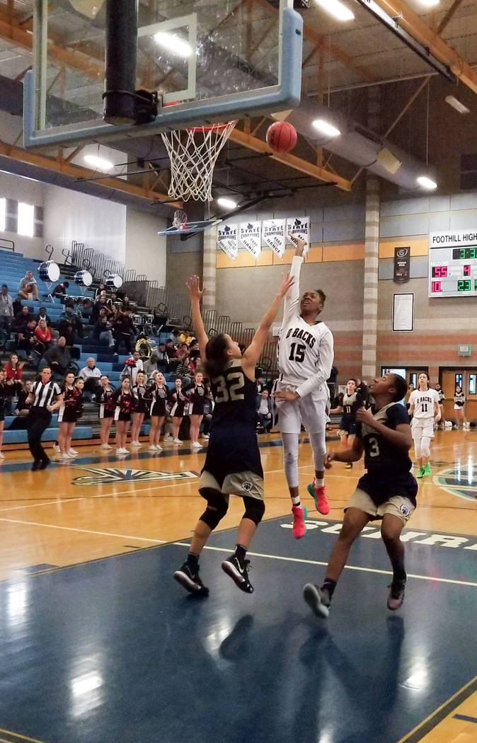 Spring Valley’s Ahmaya Smith shoots over Spring Valley’s Garrisen Freeman during ...