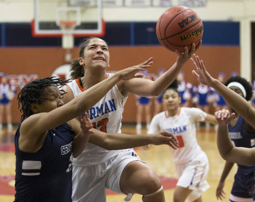 Bishop Gorman senior Georgia Ohiaeri (13) drives past Centennial junior Daejah Phillips (15) ...