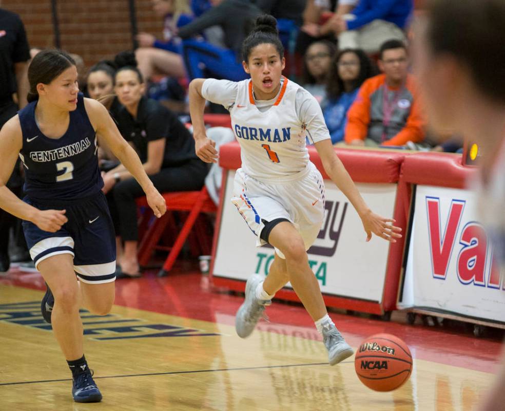 Bishop Gorman senior Caira Young (1) pushes the ball up court past Centennial senior Melanie ...