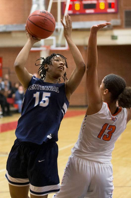 Centennial junior Daejah Phillips (15) shoots over Bishop Gorman senior Georgia Ohiaeri (13) ...