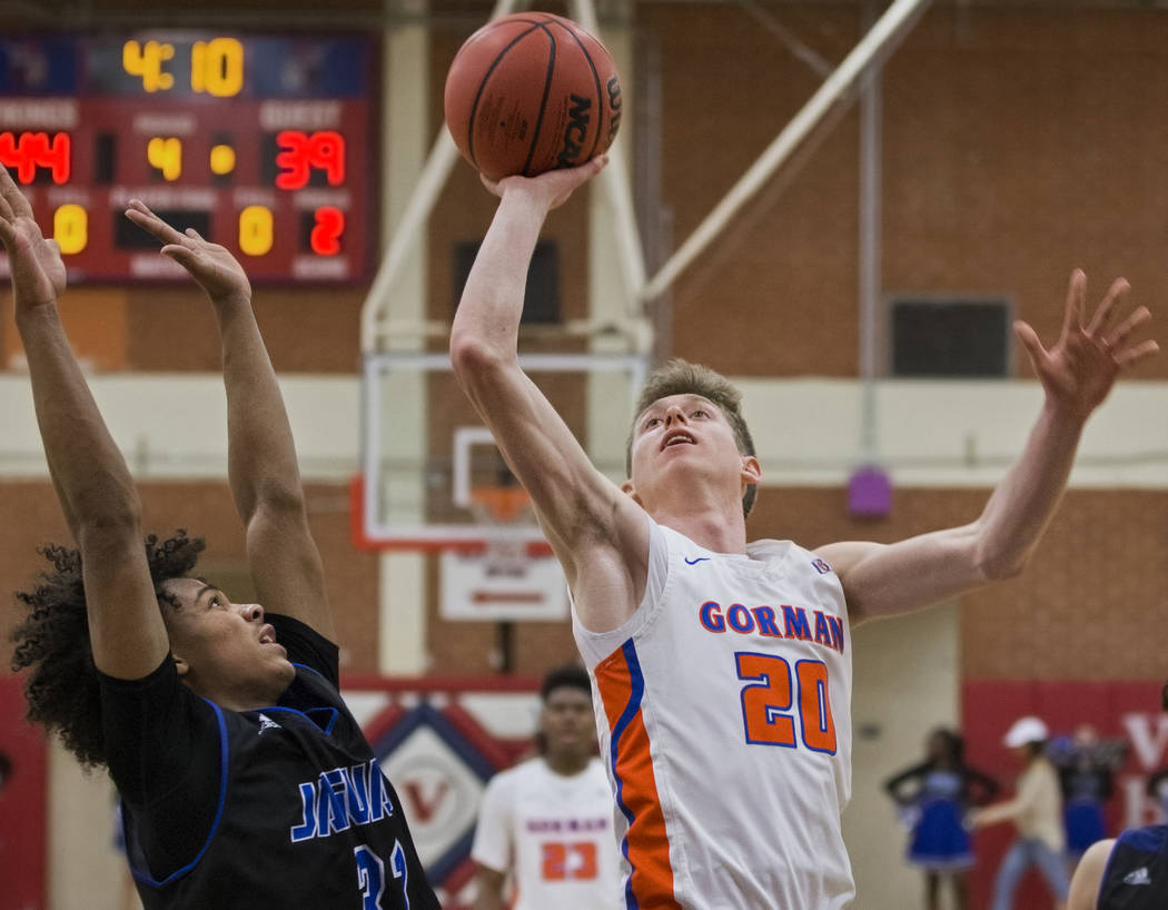 Bishop Gorman senior guard Noah Taitz (20) drives past Desert Pines freshman Jamir Stephens ...