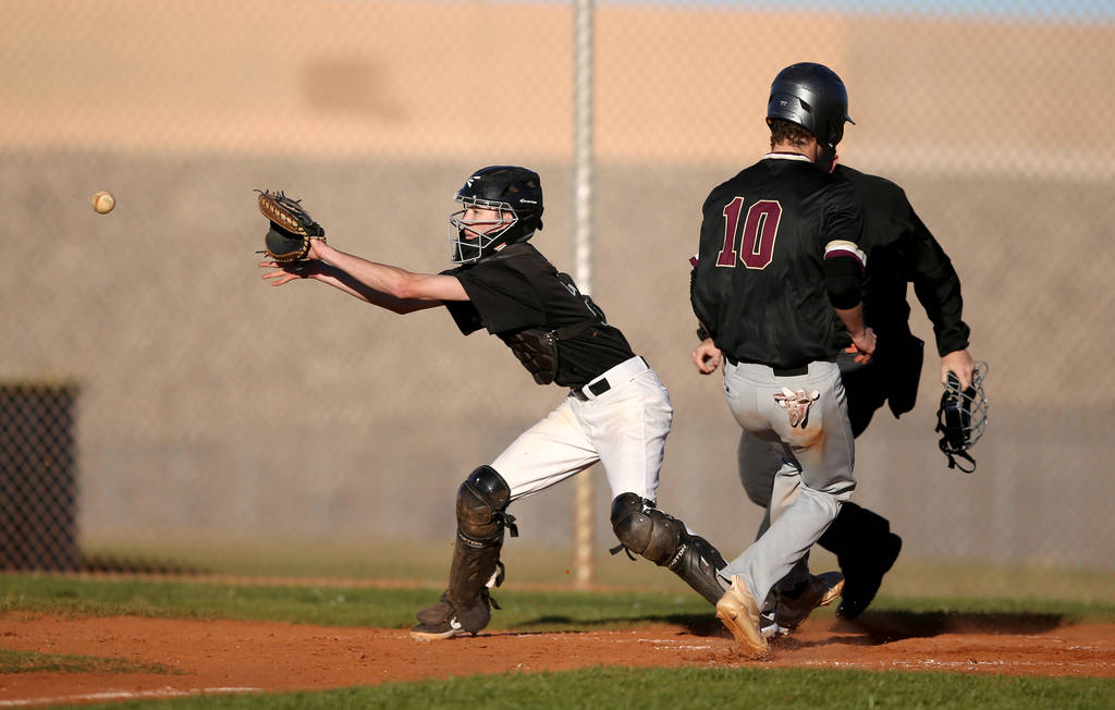 Faith Lutheran Michael Carroll (10) crosses home as Silverado catcher Seton Cifelli (21) fie ...