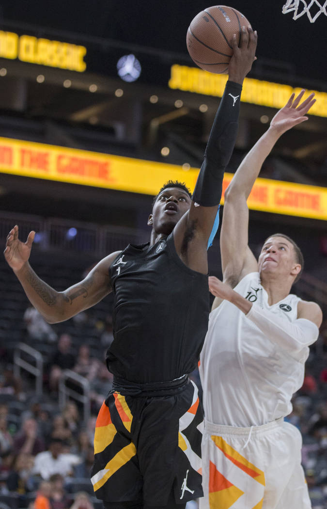 Rocket Watts (1) slices to the rim past Samuell Williamson (10) in the first half during the ...