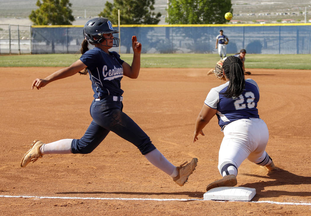 Centennial outfielder Abby Hanley (12) runs safely into first base as the ball is thrown to ...