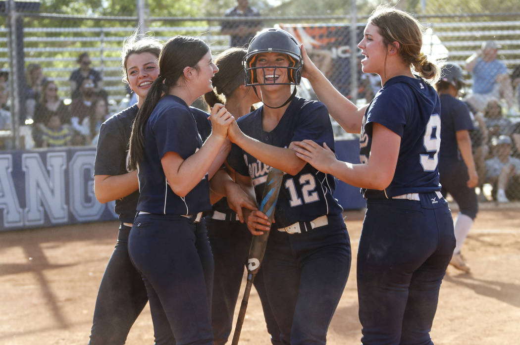 Centennial’s Abby Hanley (12) is congratulated by her teammates after scoring a run in ...