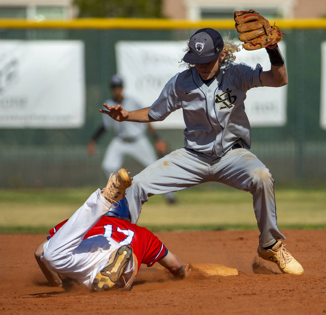 Liberty’s Ethan Safier (17) dives back to second base below Spring Valley’s Chas ...