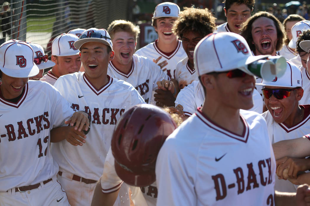 Desert Oasis celebrate a two run homer by Campbell Holt (16) against Basic in the Desert Reg ...