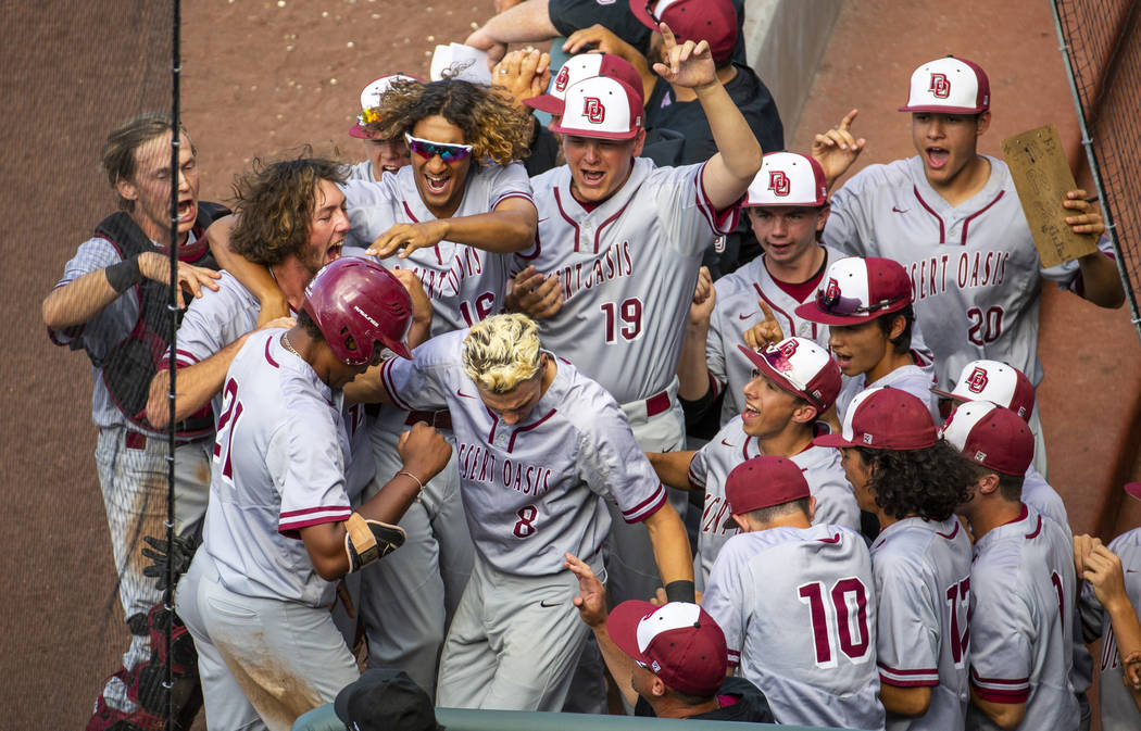 Desert Oasis teammates celebrate a run by Jacob Walsh (21) over Reno in the second inning du ...