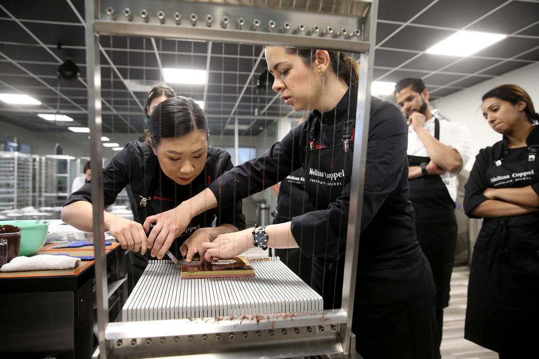 Melissa Coppel helps student Alisha Handelman of New York slice her chocolates at her Las Vegas ...
