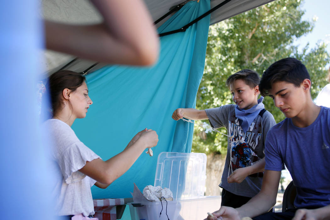 Siblings Cortlin Talbot, 17, left, Ry, 8, and Trayle, 13, play with their string toys during Pi ...