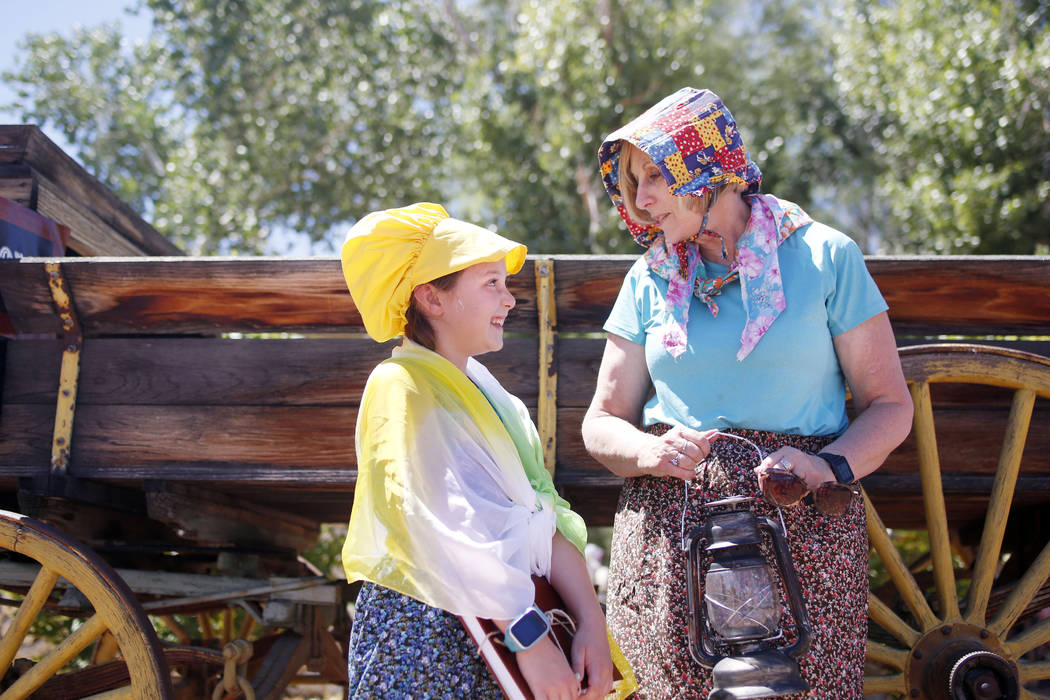 Aubrie Kundanani, 9, and Kathie Kundanani take pictures at the photo booth during Pioneer Day a ...