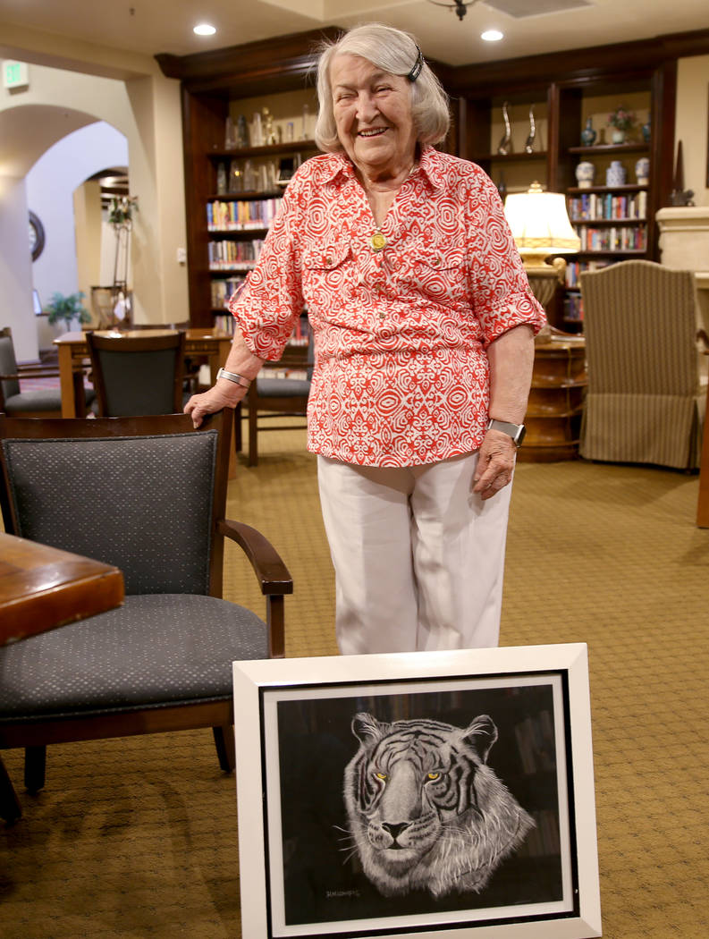 Artist Hannelore Lowrey shows one of her pieces in the library of her living facility Wednesday ...