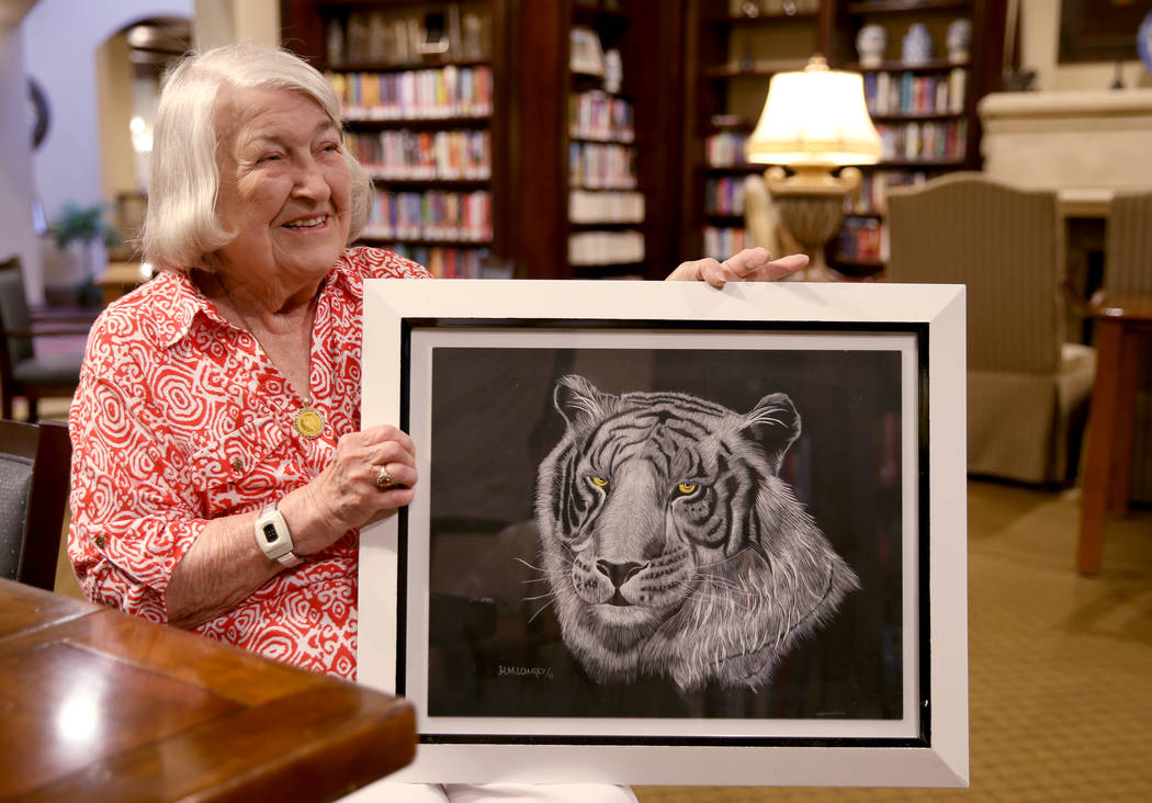 Artist Hannelore Lowrey shows one of her pieces in the library of her living facility Wednesday ...