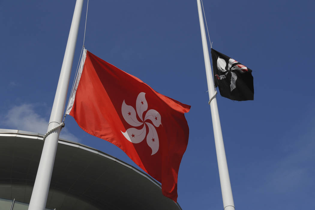A black Hong Kong flag flies as protesters replaced with the Chinese flag that is normally set ...