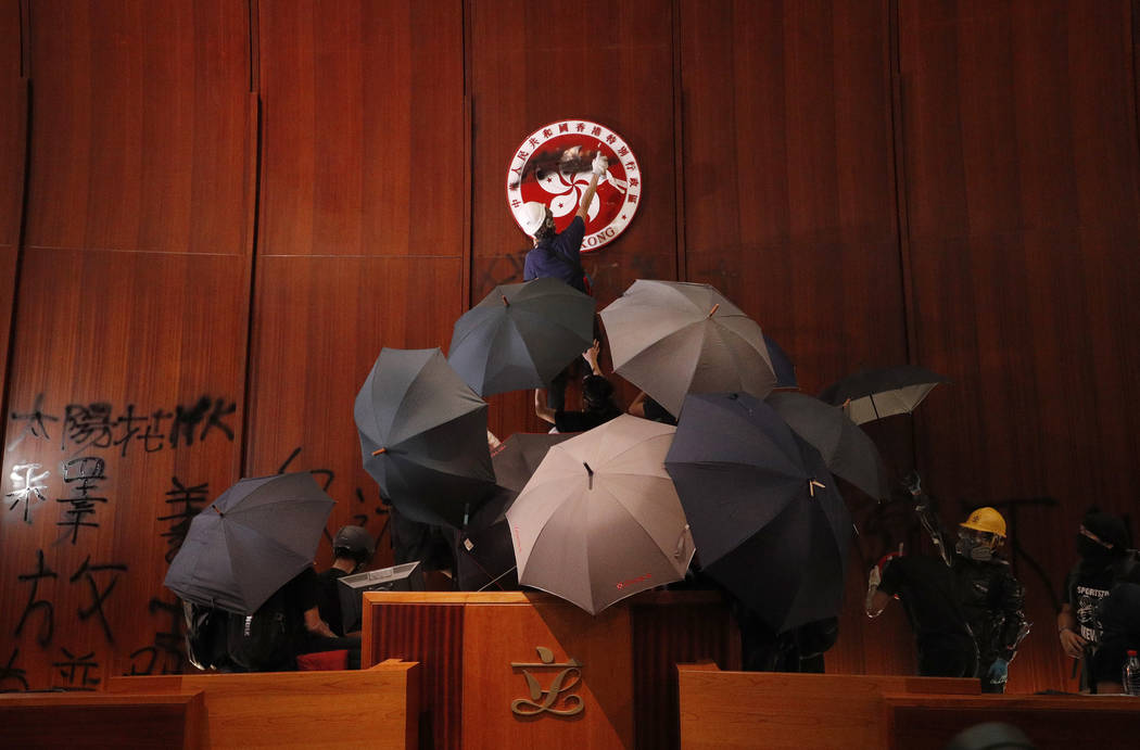 Protesters deface the Hong Kong logo at the Legislative Council to protest against the extradit ...