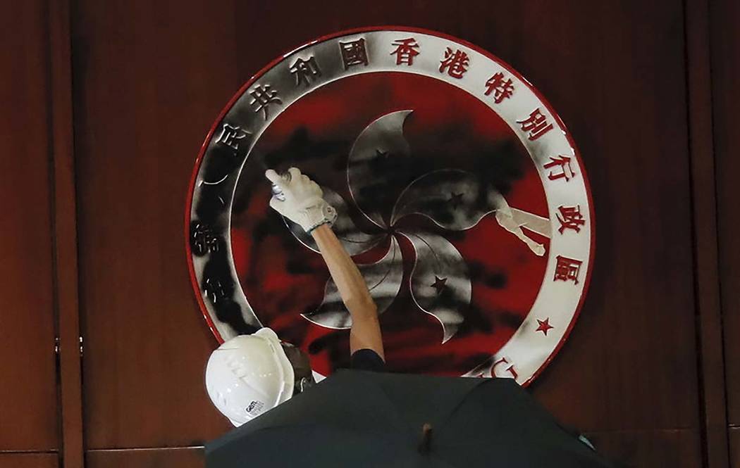 A protester defaces the Hong Kong emblem after they broke into the Legislative Council building ...