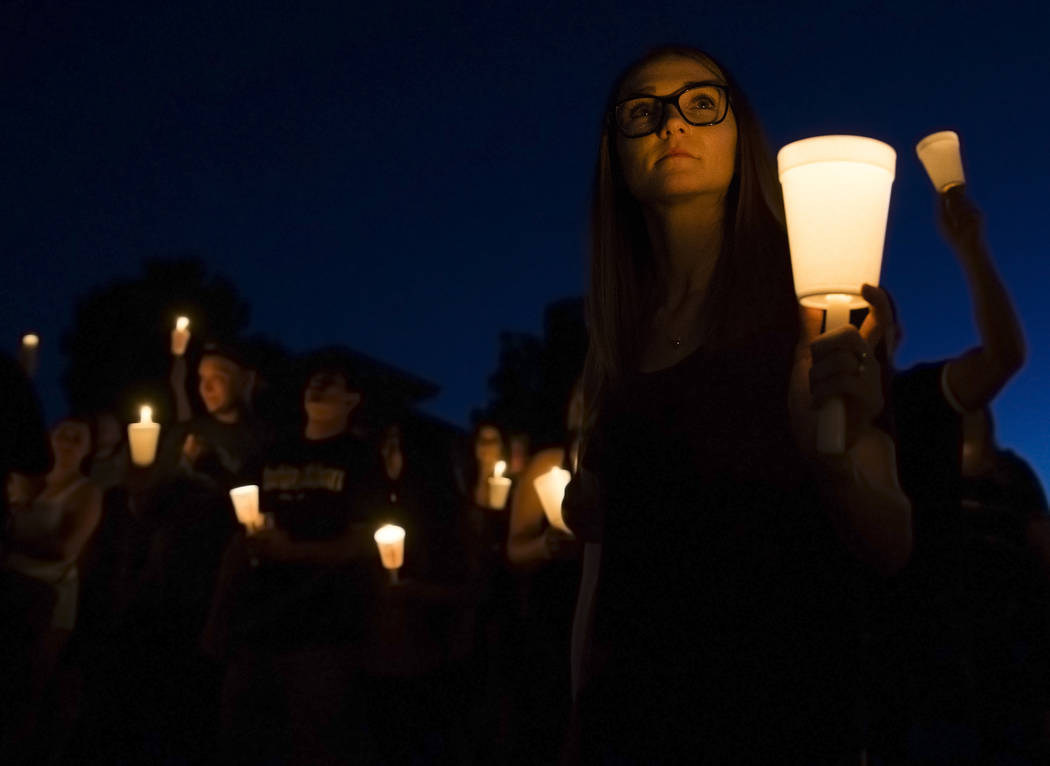 Kimber McMillan, right, holds a candle during a vigil for her friend Max Garcia Monday, July 1, ...