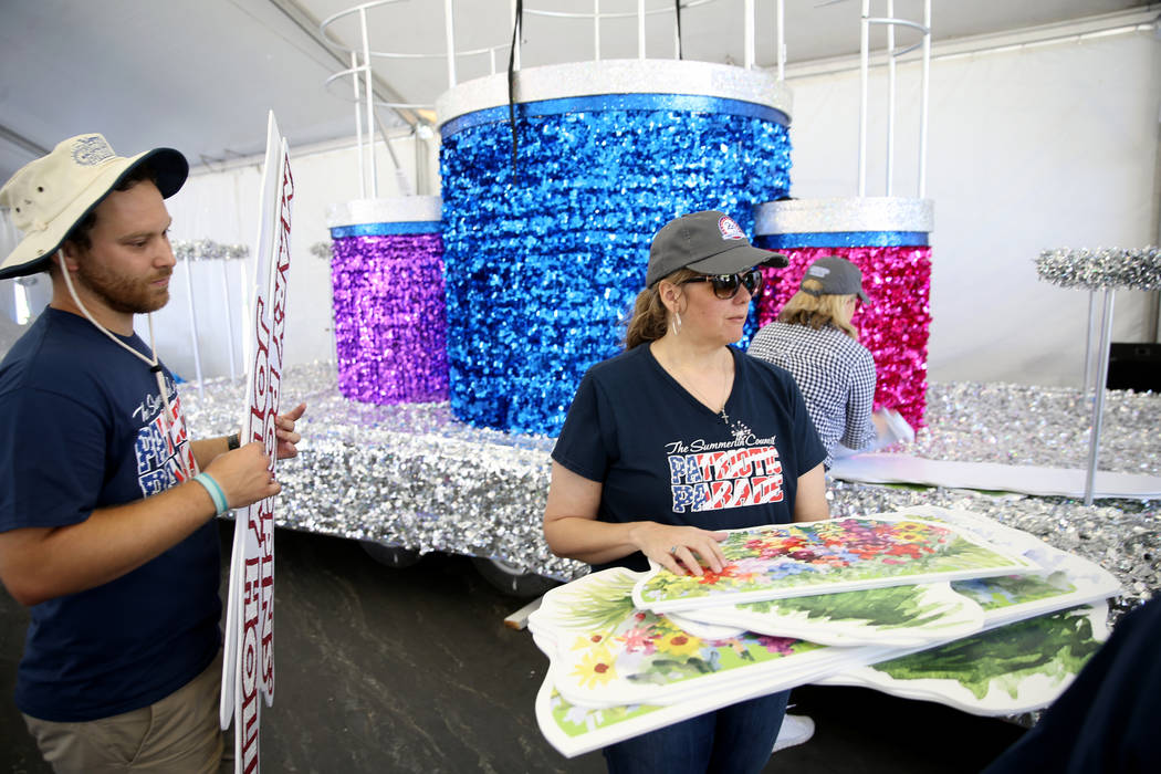 Julien Mihy, left, and Kelly Cawood work on the "Mary Poppins Jolly Holiday" float during a med ...