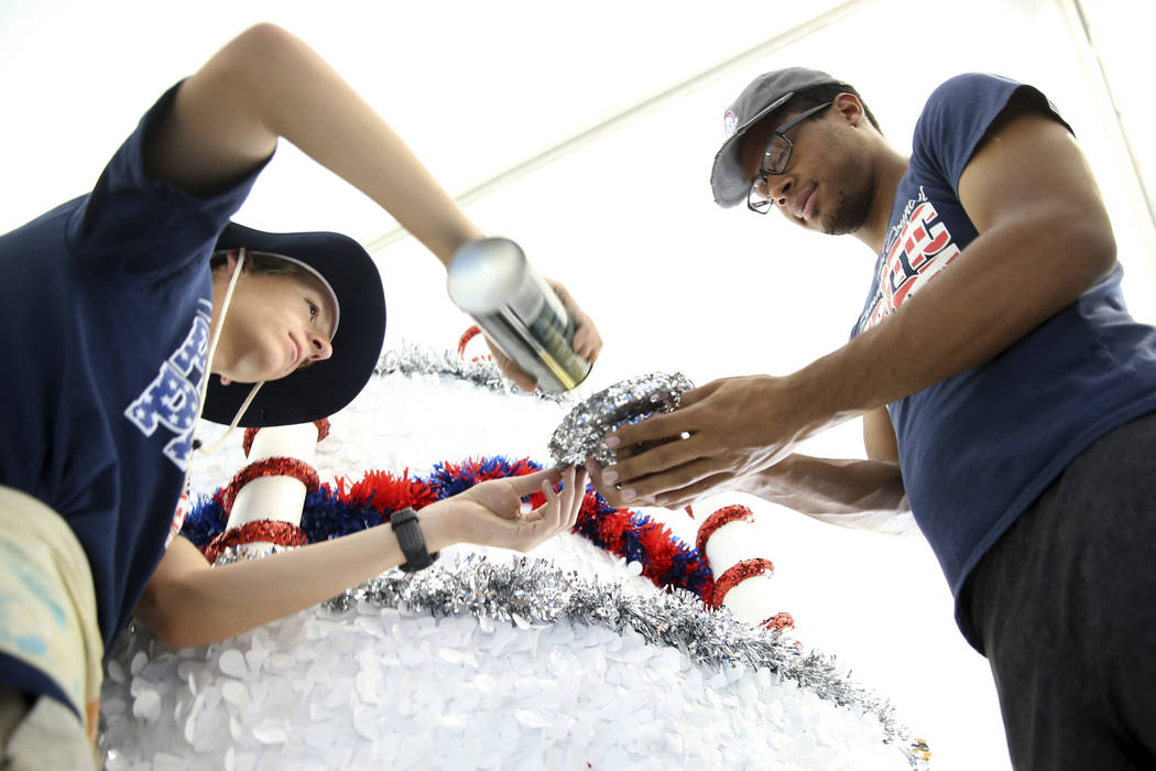 Connor Jordan, left, and Dwight Jones work in the Happy Birthday America float during a media p ...