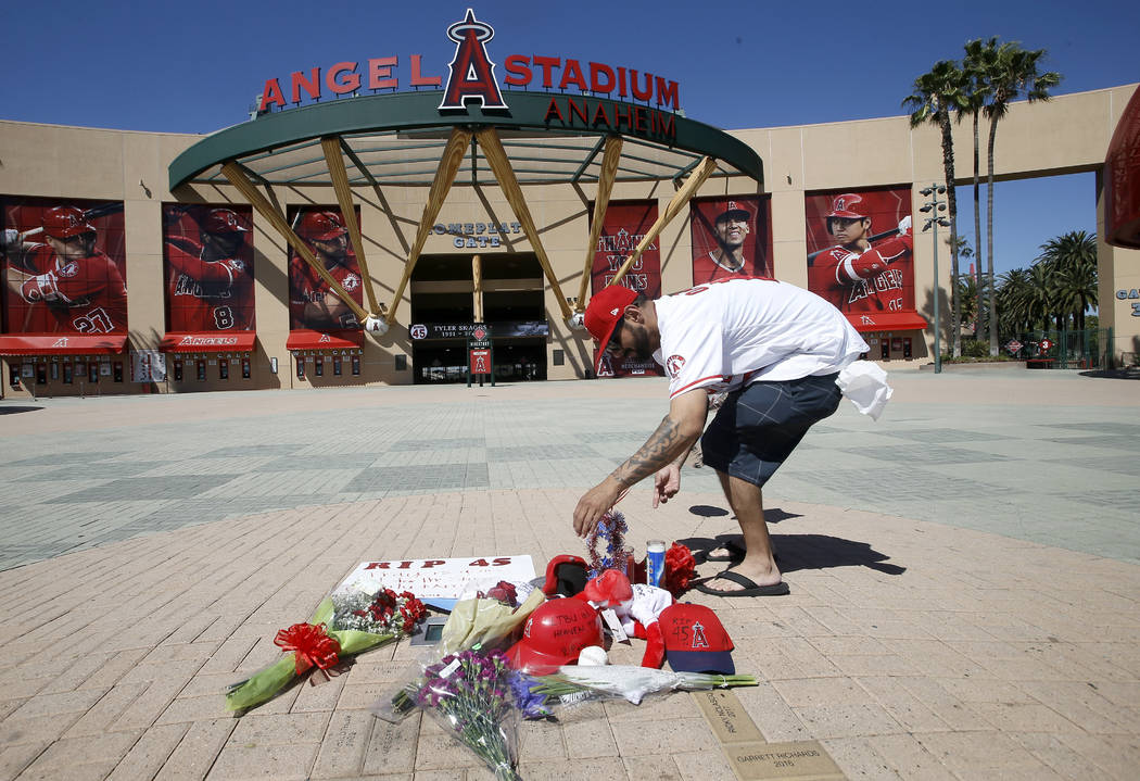 Los Angeles Angels fan Steven Beltran adds to a makeshift memorial at Angels Stadium in Anaheim ...