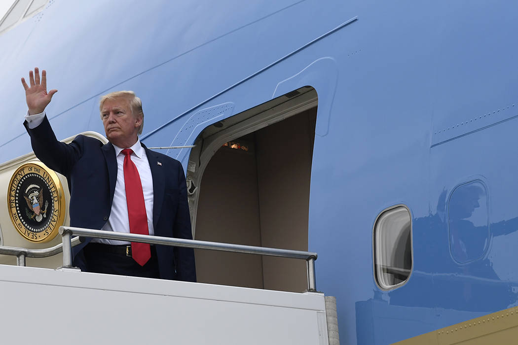 President Donald Trump waves from the top of the steps of Air Force One at Osan Air Base in Sou ...