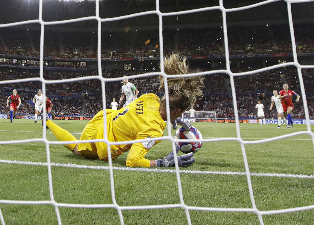 United States goalkeeper Alyssa Naeher saves a penalty shot taken by England's Steph Houghton d ...