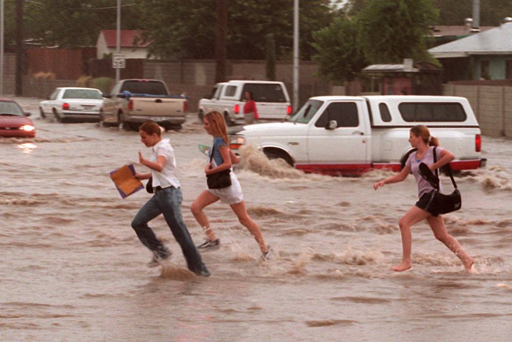 School Kids cross a flooded street near Washington and Pecos. (Las Vegas Review-Journal)
