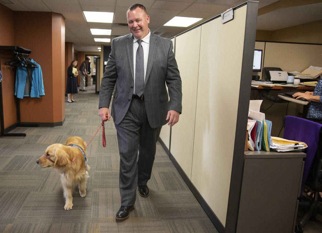 Bill Kube, a victim/witness advocate, walks Norie, the Ramsey County attorney's office new faci ...
