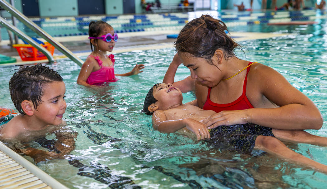 Swim instructor Shanneal Ocular, right, helps her student Stefan Flores, 4, to float during a b ...