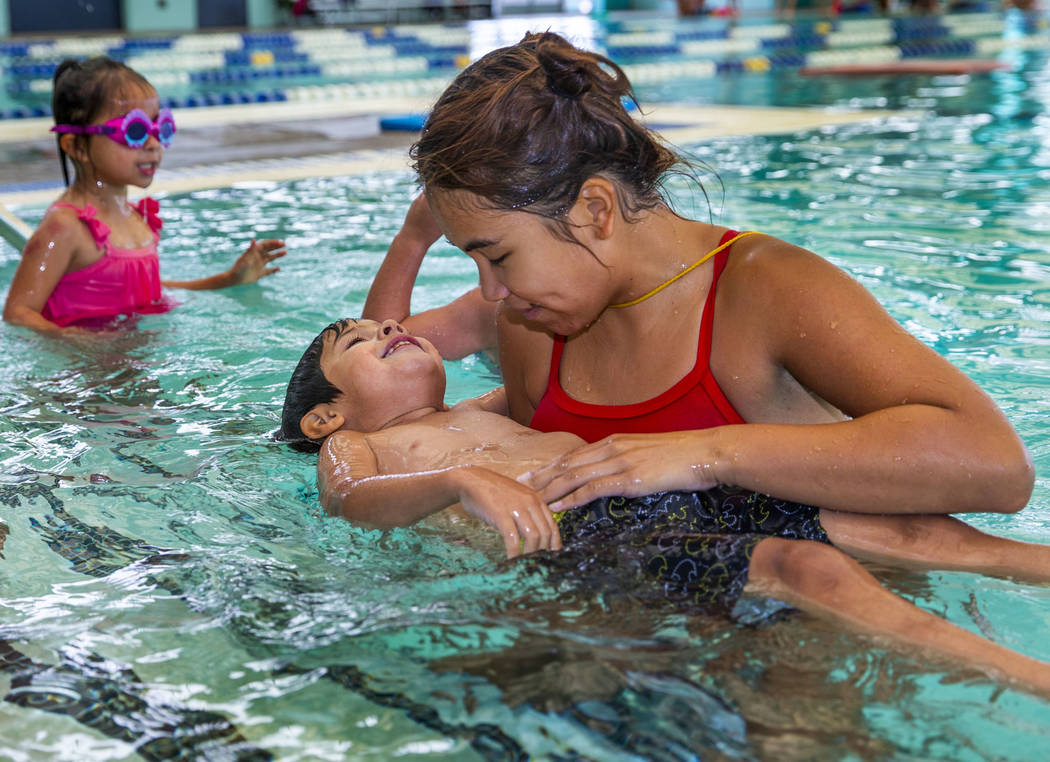 Swim instructor Shanneal Ocular, right, helps her student Stefan Flores, 4, to float during a b ...
