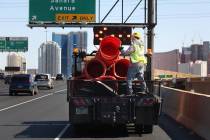 Crews work to remove orange safety barrels along Interstate 15 near the Sahara Avenue exit on M ...