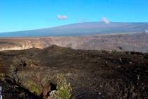 In this April 25, 2019 photo, Hawaii's Mauna Loa volcano, background, towers over the summit cr ...