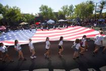 Members of the Palo Verde High School track team march with a giant American Flag during the Su ...