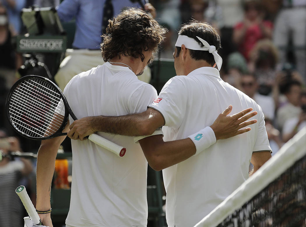 Switzerland's Roger Federer, right, greets South Africa's Lloyd Harris at the net after winning ...
