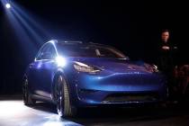 Tesla CEO Elon Musk, right, stands next to the Model Y at Tesla's design studio Thursday, March ...