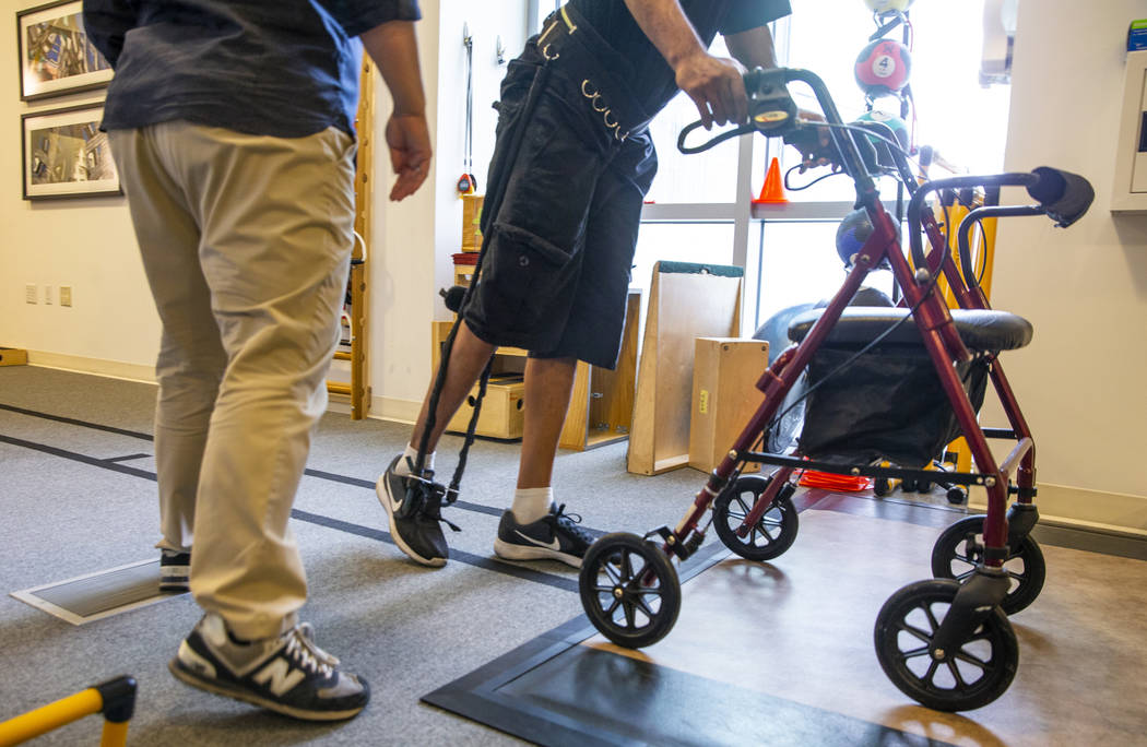 Physical Therapist Christine Ross works with a patient on a walking exercise within the therapy ...