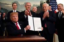 President Donald Trump holds up a signed proclamation recognizing Israel's sovereignty over the ...