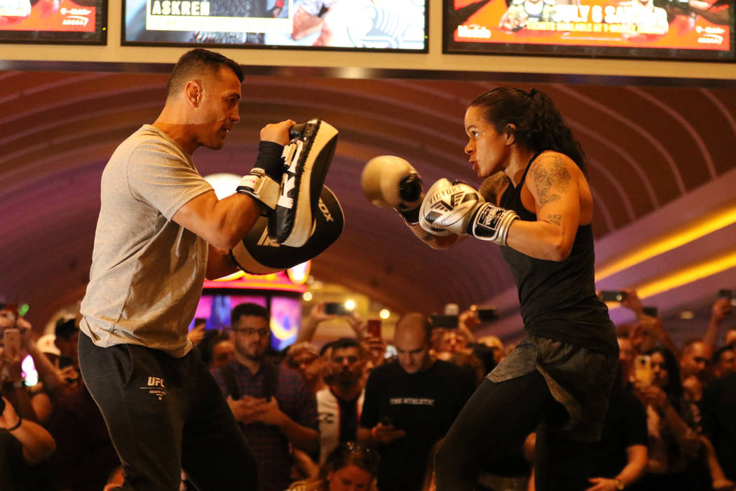 UFC women's bantamweight and featherweight champion Amanda Nunes, right, hits mitts with her co ...