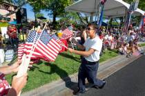 Angel Lemurs, 16, hands out American flags during the 25th annual Summerlin Council Patriotic P ...