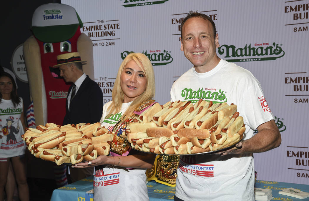 Eleven-time and defending men's champion Joey Chestnut, right, and defending women's champion M ...