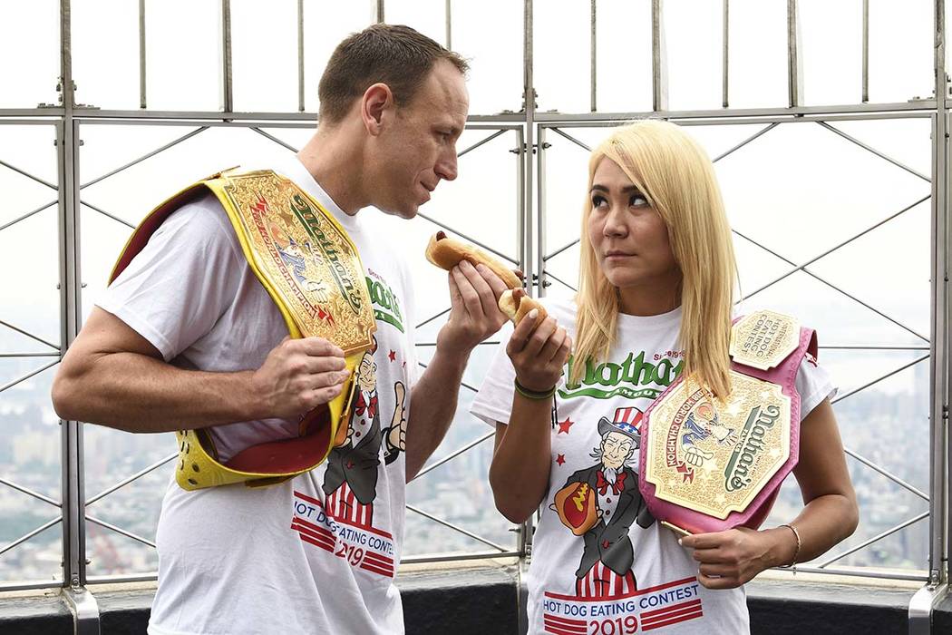 Eleven-time and defending men's champion Joey Chestnut, left, and defending women's champion Mi ...