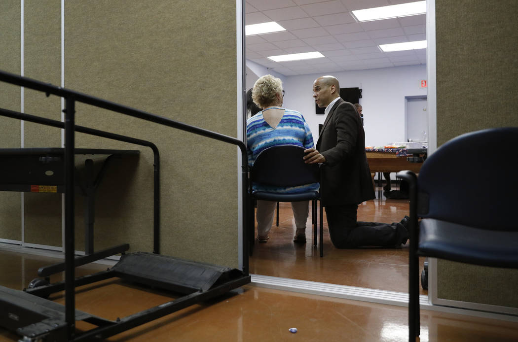 Democratic presidential candidate Sen. Cory Booker, right, speaks with Liz Geffon at a Veterans ...