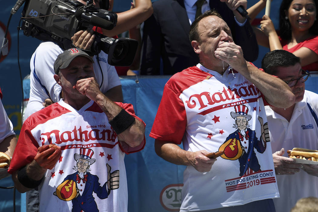 Geoffrey Esper, left, and Joey Chestnut, right, compete during the men's competition of Nathan' ...
