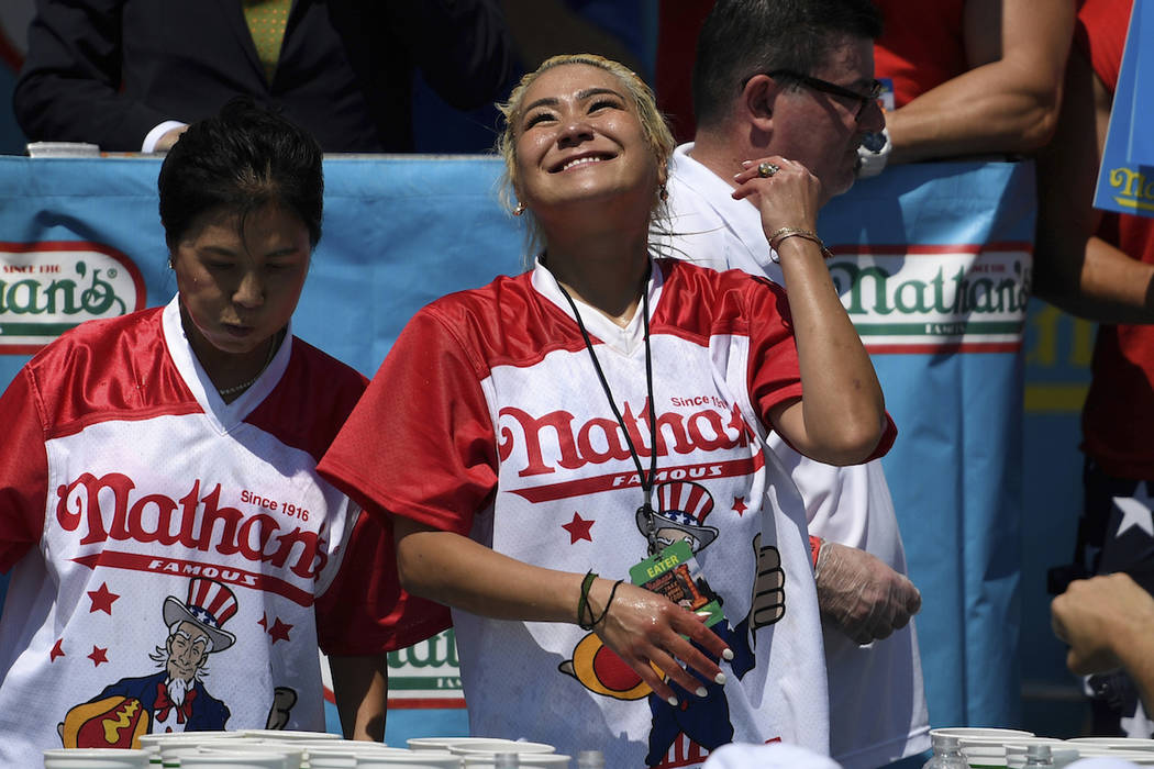 Miki Sudo, right, reacts after eating 31 hot dogs to win the women's competition of Nathan's Fa ...