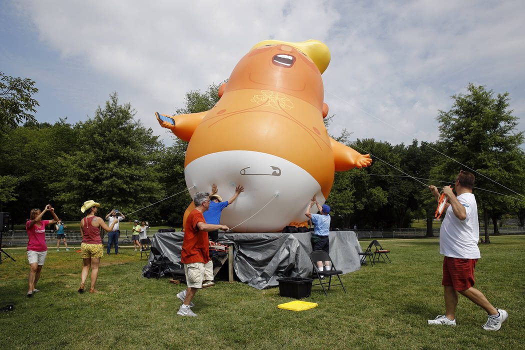 Protesters move a Baby Trump balloon into position before Independence Day celebrations, Thursd ...
