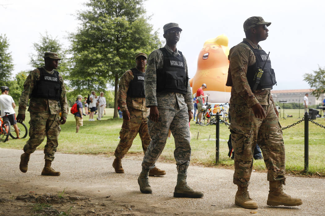 Members of the District of Columbia National Guard walk near a Baby Trump balloon before Indepe ...