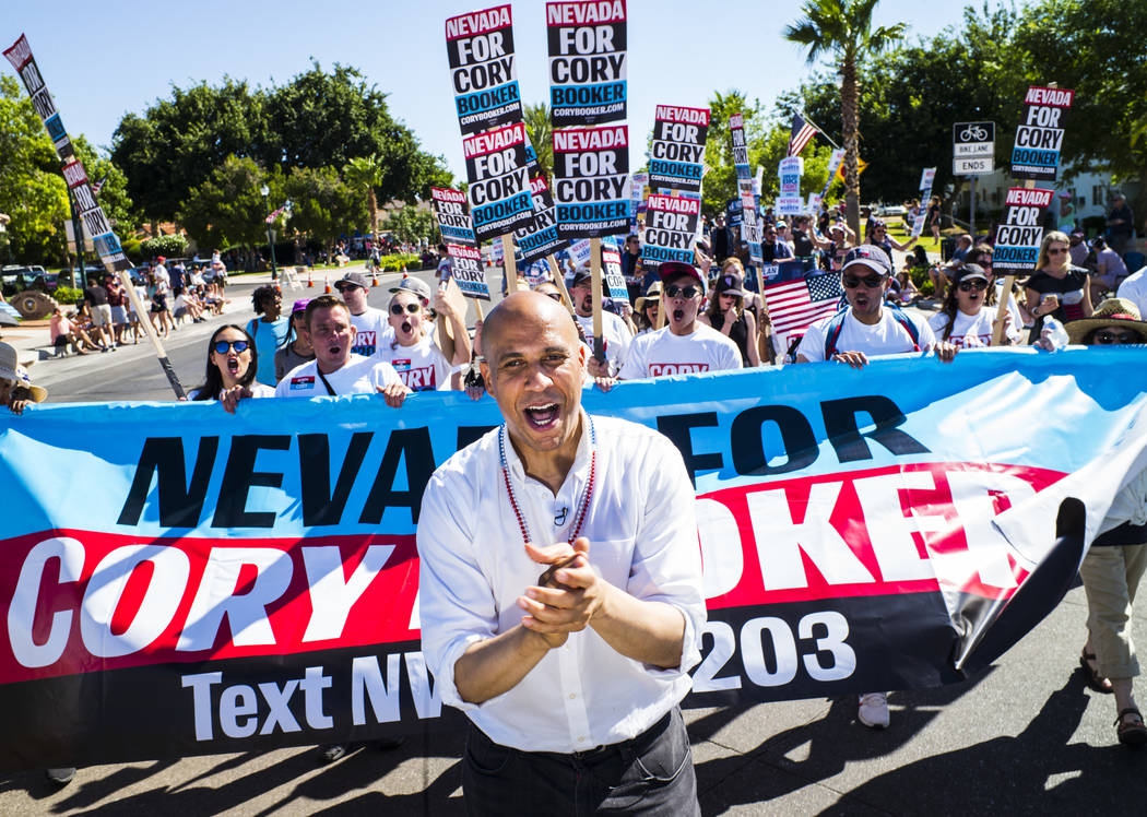 Democratic presidential candidate Sen. Cory Booker, D-N.J., marches with supporters in a parade ...